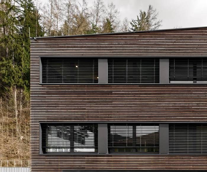 Particolare facciata esterna in legno e finestre a nastro, Centro Sociale Trayah, Roland Baldi Architects.